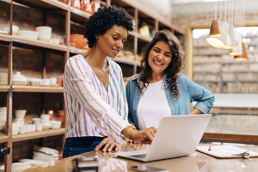 Business owners using a laptop together in their store